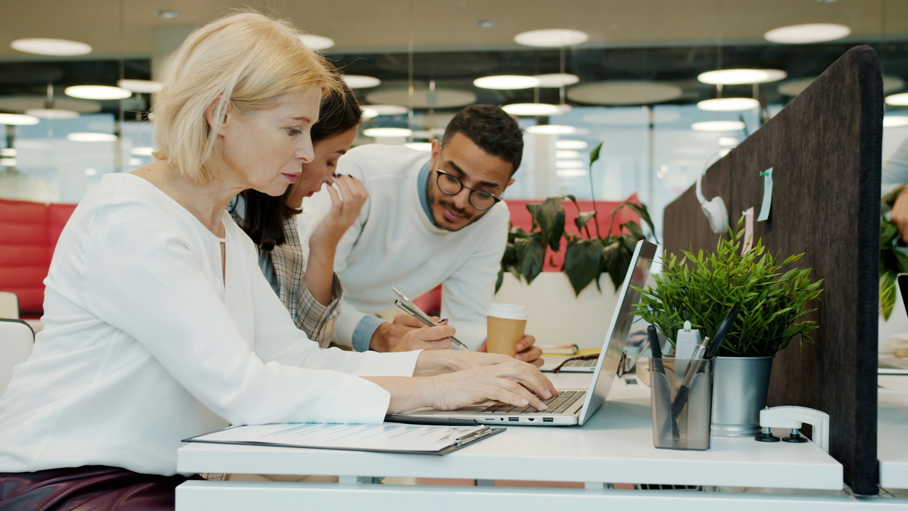 Technical hiring team reviewing candidates around a laptop